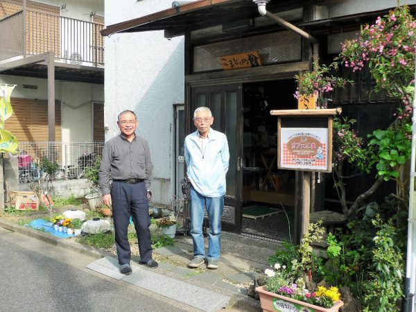 「こまじいのうち」マスターの秋元康雄さん(右)と、スタッフの山上良一さん。山上さんは「みまもりサポーター」グループのメンバーとして関わるようになり、今では「こまじいのうち」のコアスタッフとして会計などを担当している