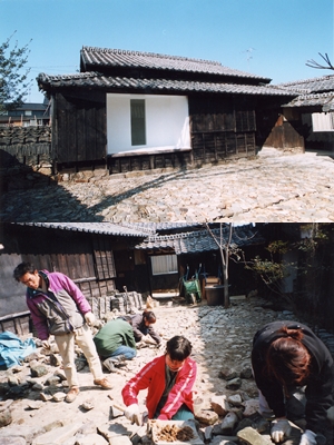 写真上:2003年のワークショップで作品化された「白い部屋」。黒壁の外壁と対照的な白の漆喰がアーティストとボランティアの手で塗られた。<br>
写真下:浜を何往復もして佐久石を庭に敷き詰める作業はかなりの重労働だったそう。できた庭は「緑の庭」と名付けられた<br>写真提供/佐久島振興課