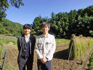 ▲神奈川県住宅供給公社の部長・渡辺哲さん(右)と主任・秋山裕規さん(左)。ちょうどこの日は地域のみなさんと稲作体験をしている田んぼの稲刈りの日だったため、スタッフ総出でゴム長を履いて朝から作業をしていたそう。「団地のみなさんに田植えや稲刈りなど、都会ではできない体験をしていただくことで、この場所で暮らすことの魅力を感じていただけたら嬉しいですね」(渡辺さん)<br />「僕はまだ4月に赴任したばかりですが、まちの中を歩くと皆さんが気さくに挨拶をしてくださるので、すでに顔見知りばかり(笑)。“二宮町には何もない”とおっしゃる地元の方もいらっしゃいますが、実は“何もない”のではなく“気づいていない”だけだと思います。そんな魅力の発見を、僕のように外から来た人間が少しでもお手伝いできたら…と思っています」(秋山さん)