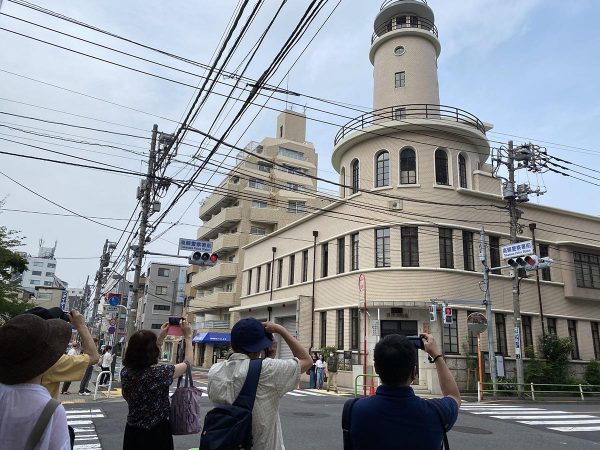 山手線ツアーの様子。隈研吾設計の高輪ゲートウェイ駅から品川駅へ。途中にある建築を見ながら、土地の歴史を掘り起こしていく。写真は高輪警察署二本榎出張所