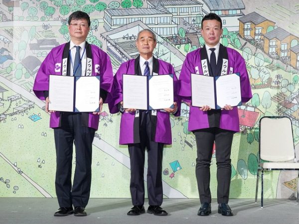 紫波町の町の花、「ききょう」の色でもある紫色の法被を身にまとい、株式会社よしもとエリアアクション、岩手県紫波町、株式会社オガールの3者により包括提携協定締結式が執り行われた