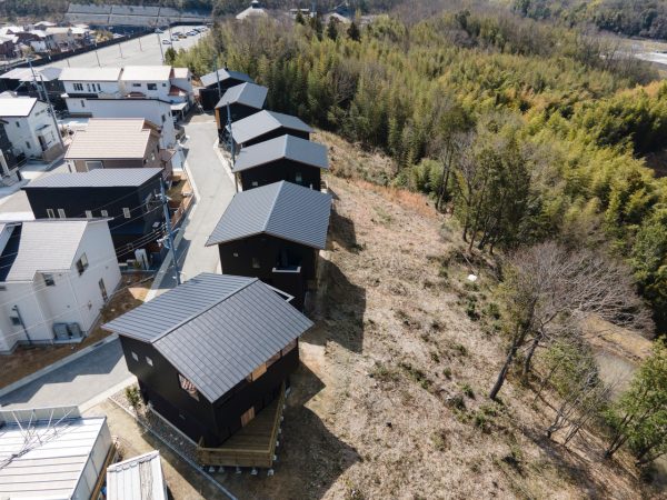 「ヨッシーワンズガーデン木津梅美台・リンクプロムナード」。6住戸が共同利用する北側斜面地には、安全に昇降できるスロープ、大小のデッキテラス、6住戸分の菜園。さまざまな大きさの樹木が日当たりや機能面を考慮して配置されている。2020年グッドデザイン賞受賞。写真提供:有限会社ランドサット一級建築事務所