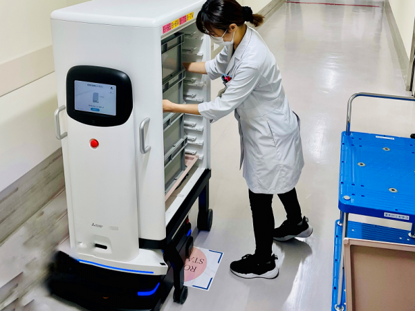 三菱電機株式会社の病院向け搬送サービスロボット「MELDY」。従来の搬送ロボットは走行部とカートが一体化されているものが多かったが、脱着型カート方式にすることでロボットを呼び出す前に収納作業が行え、実用性を高めた(写真提供:愛知県)