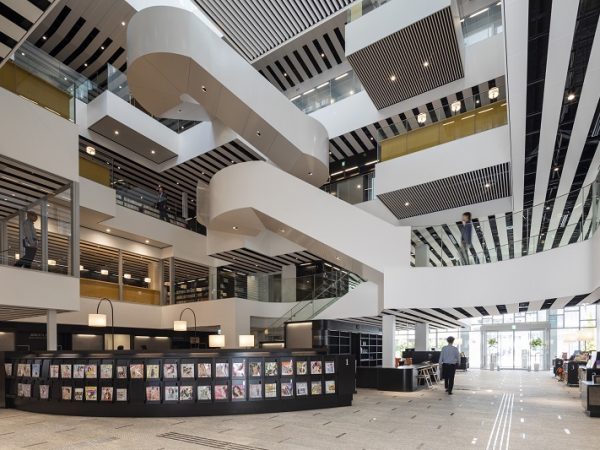 1階南入口付近のエントランスエリア。縞模様に見える天井は、空調などの設備面にも関係しているが、白黒の縞模様がデザイン性も生み出した(写真提供:小牧市中央図書館)