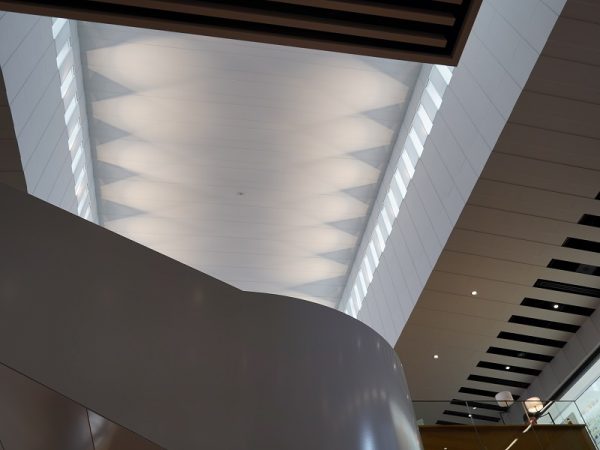 1階南入口付近のエントランスエリア。縞模様に見える天井は、空調などの設備面にも関係しているが、白黒の縞模様がデザイン性も生み出した(写真提供:小牧市中央図書館)