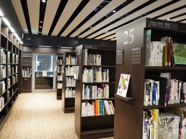 1階南入口付近のエントランスエリア。縞模様に見える天井は、空調などの設備面にも関係しているが、白黒の縞模様がデザイン性も生み出した(写真提供:小牧市中央図書館)