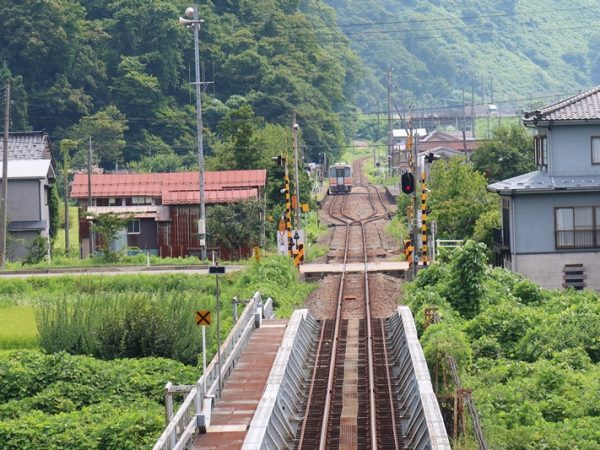 1995年の豪雨災害で被災した大糸線の現場。同線はトンネル部分が多く、写真右奥に見えているのが線路部分。中央の谷に2つの堰堤と流路を作って川に流しているそうだ