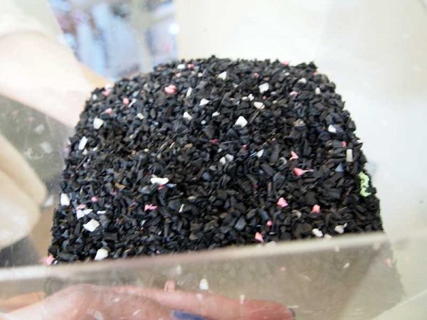 粉砕機で裁断されたプラスチックハンガー。裁断しただけではサイズが大小バラバラ、持ち寄ったものなので色もさまざま