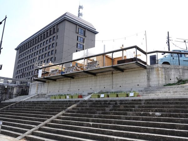 河川敷から見た殿橋テラス。かわまちづくりの始動にあたり、“水都”といわれる大阪市で水辺のプロジェクトを多数手がけていた有限会社ハートビートプランの代表・泉英明氏を勉強会に招いた。殿橋の橋詰を訪れた泉氏から、川だけでなく岡崎城も見える景観のよい場所を活かし、かわまちづくりの拠点を作るといいのではと提案を受けたのが殿橋テラスのはじまり。社会実験のときは単管足場を組んだデッキスペースのような仮設だったが、2021年にコンクリート製のしっかりとした空間に再整備された