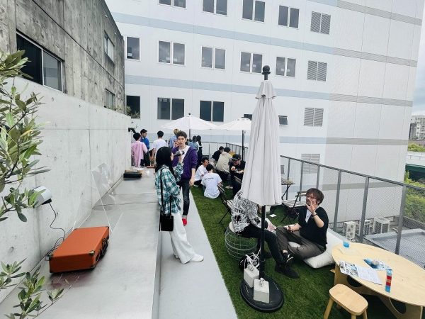 「第9回青空ルネサンス」は、名古屋市大須のビル屋上で開催。見上げると、寛いでいる参加者の姿がちらほらのぞく