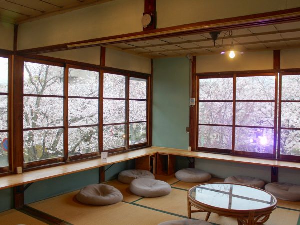 既存の構造とタイル床を合わせたおしゃれな室内。シェアキッチンには「kitchen1」といった照明が灯る