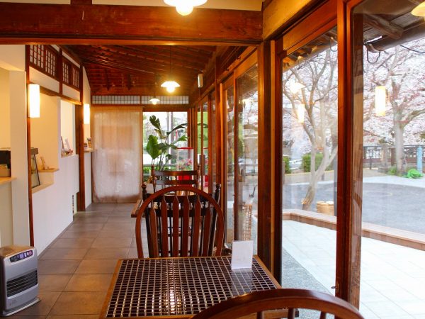 既存の構造とタイル床を合わせたおしゃれな室内。シェアキッチンには「kitchen1」といった照明が灯る