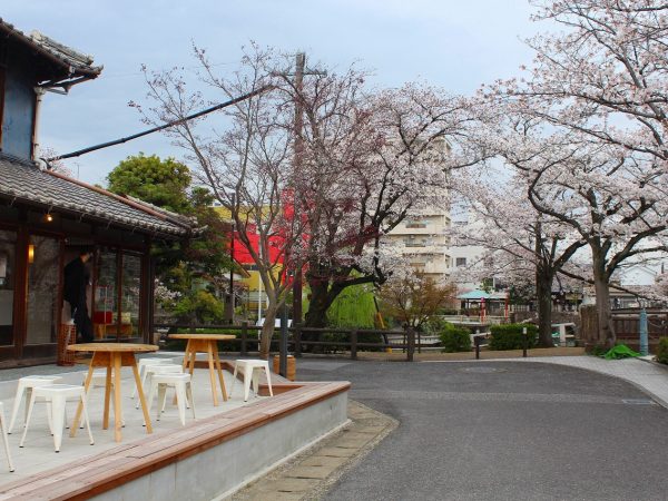 既存の構造とタイル床を合わせたおしゃれな室内。シェアキッチンには「kitchen1」といった照明が灯る