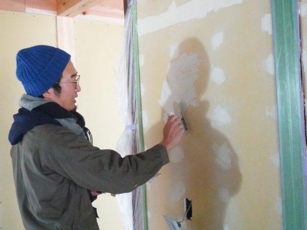 有松絞りのくくり糸を混ぜ込んだ材で塗った壁と、新旧がわかる柱(下部分が新しい)。元からあった柱をなるべく残した