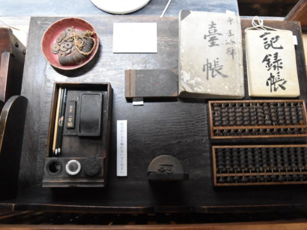 長江家らしく着物の図案帖や算盤や臺帖などが置かれた番台机