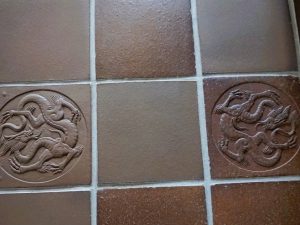 玄関脇の応接室の床には、昔からの龍の模様の敷瓦(右)と再現したもの(左)が並ぶ