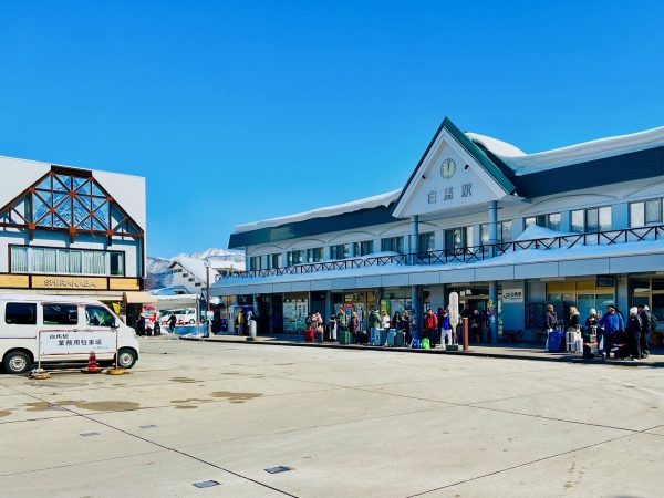 ▲白馬村の玄関口となるJR大糸線「白馬」駅。タクシー乗り場の前には外国人観光客の行列がずらりと続く。村内のタクシー台数が足りず「タクシー運転手の月収が100万円超」というニュースも話題となった(2025年2月筆者撮影)
