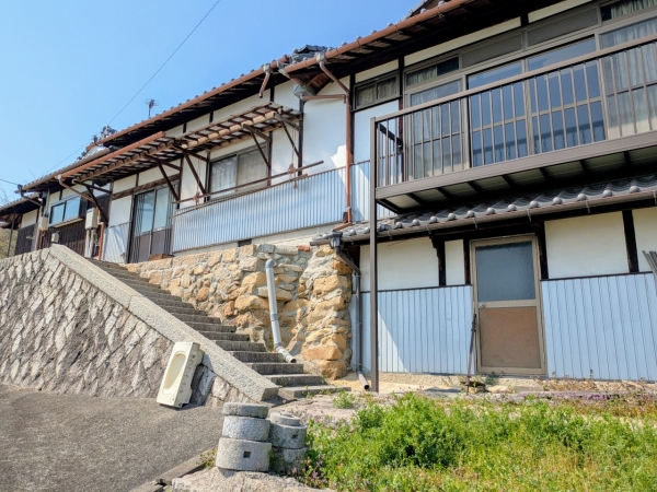 瀬戸内海を見渡せる自社オフィスの古民家前に立つ株式会社miluma代表 守本さん