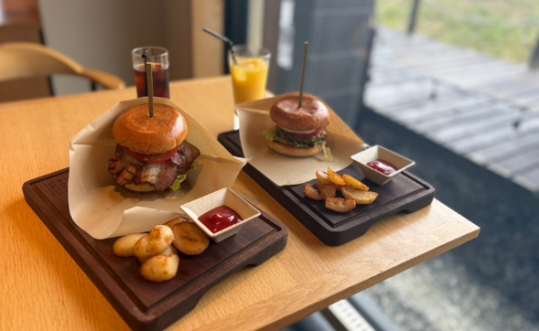 Black Wood Grillで提供されるハンバーガー。左は2,800円、右は1,500円。北海道産牛肉のパテを薪火で焼き上げ、真狩豚の自家製ベーコンや真狩村産ジャガイモを使用している。
