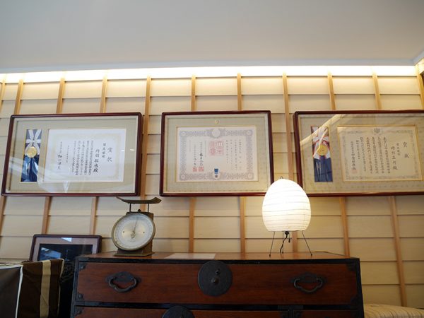 卓越した技能者に与えられる「現代の名工」、藍綬（らんじゅ）褒章も受賞している正行さん。店内にはずらりと賞状が並ぶ。全国各地からその技術を学びたいとやってくる布団職人たちに、正行さんは自分が培ってきた技術を惜しげもなく教えるのだという