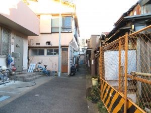 地域内で大きくセットバックして建替えられた住宅と、増築で道にはみ出した住宅（右）。元々は広い道路だったはずなのだが
