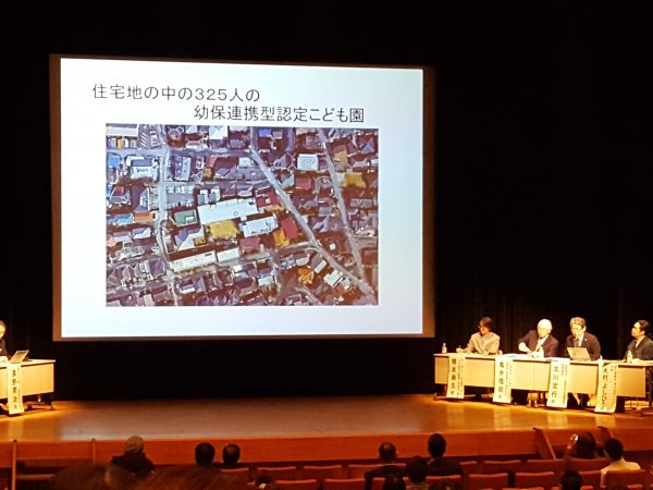 パネルディスカッション中の1コマ。北川氏による自園の紹介の様子。メンバーは大阪大谷大学 人間社会学部 教授の農野寛治氏をコーディネータに、本日の登壇者である橋本氏を有識者に迎え、パネリストは社会福祉法人 大阪府社会福祉協議会 保育部会 副部会長 亀井信昭氏、一般社団法人 大阪府私立幼稚園連盟 副理事長 北川定行氏、設計事務所 株式会社VANS 代表 木村よしひろ氏