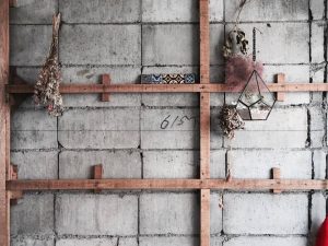 古い壁をめくって現われたコンクリートをそのまま生かした壁面。木やグリーンをあしらうことで温かい表情を加えた