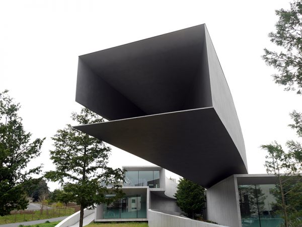 公園側から見たホキ美術館。グレーの飛び出た箱のような建物が1階、企画展を展示するギャラリー1だ。レストランやカフェ、保木氏の陶磁器コレクションの展示が見える