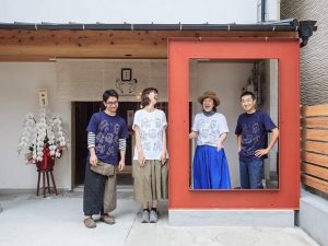 左からスタッフの中村さん、鈴木さん、店長の葛西さん、オーナーの吉澤さん。玄関前の“ガクブチ”では、宿泊者とスタッフの思い出に記念撮影をすることができる