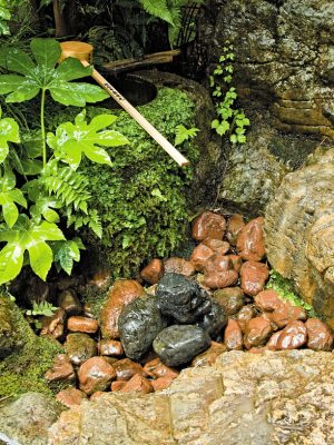 ▲水琴窟というのは江戸時代に多く造られた日本庭園の装飾の一つ。手水鉢近くの地中の空洞に水滴を落下させることで、何とも不思議な透明感のある音色が響き渡る（写真は復元された『今井家住宅』中庭の水琴窟）