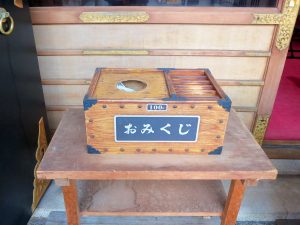 箱の上に開けられた穴から引くタイプのくじ。無人のおみくじ販売所ではこの方式をよく見る