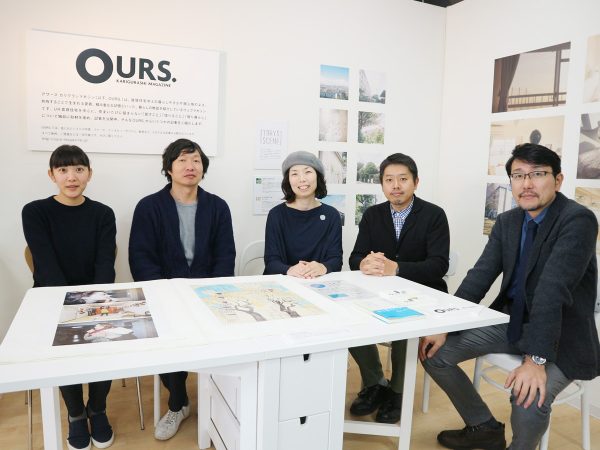 今回お話を伺ったOURS.に携わるスタッフの皆さん。左から株式会社フォトアンドカラーズ 制作担当 助口優衣さん、</BR>Re:S 竹内厚さん、フォトアンドカラーズ代表取締役 平野愛さん、株式会社フォトアンドカラーズ 制作担当 松川祥広さん、UR都市機構 大阪エリア経営部企画課長 西山直人さん。撮影場所は、UR梅田営業センター内にあるOURS.のブース。</BR>Webの世界がそのまま飛び出したかのように作品、出版物が紹介されている