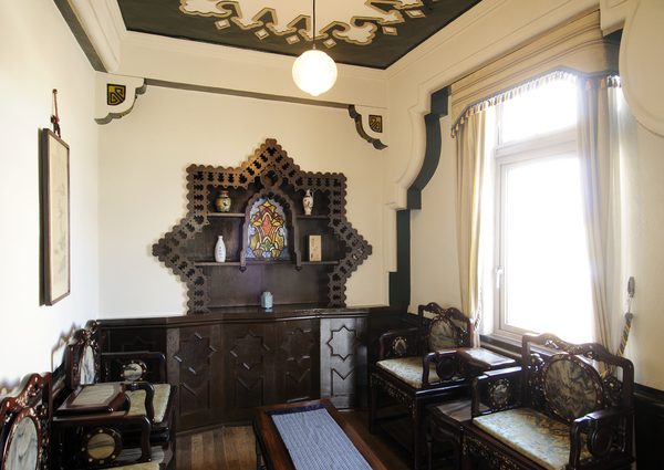 1924年アメリカOTIS社製のエレベーター。ドアは蛇腹方式（上）で、鉄扉と鉄格子が開閉し、古い映画を見ているようなレトロ感が漂う。階数表示板は半円状で、針がエレベーターの動きを知らせる。最上階のみ下向き半円状（左下）。重量は2000LBSとポンド表示だ（左下）