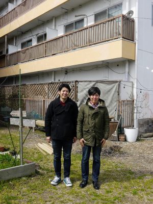 「HandA Apartment」の庭に立つ半田兄弟。右が兄・啓祐さん、左が弟・満さん。