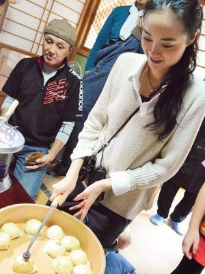 饅頭づくりで焼き印に挑戦する参加者