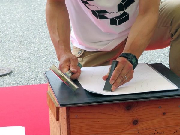 お披露目会では植田板金店の辰巳健吾氏がたがねを使って外壁の一部を作る作業を実演した。薄い板に的確に模様が刻まれていく様子はさすが、職人技