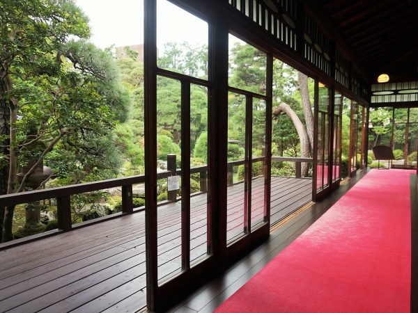 廊下のガラス窓を通して部屋から庭園が美しく見える