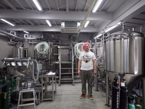 工場長のアブサル・アーロン氏と醸造所の様子。１樽400L。現在10ブランドを展開で、再生産が追いつかないものも既にある。今後は月に１つずつ新作を展開していく予定だそう