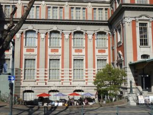 南側外観。パラソルが並んでいるところがサンクンガーデン。一部はレストランのテラス席になっている。サンクンガーデンの両脇に地階への入り口がある（写真提供：大阪市中央公会堂）