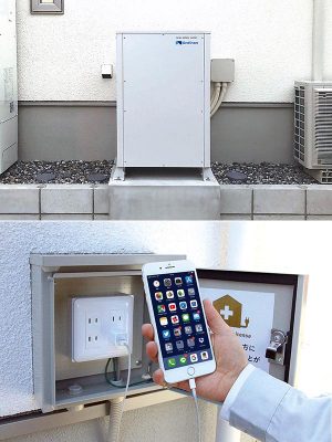 【写真上】IHクッキングヒーターなどの200V機器にも対応できる9.8kWhの蓄電池システム。深夜電力から充電するのではなく太陽光発電システムからの直接充電が可能だ。<br><br>【写真下】屋外に取り付けられた非常用コンセント。非常時には近所で停電している家に電気をシェアすることができる