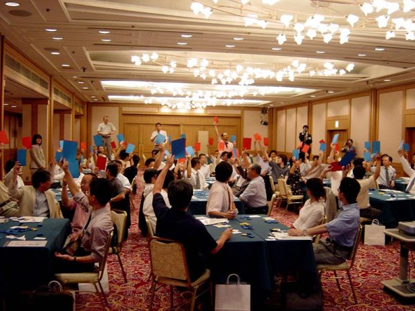 20人でプレイできるセットが販売されているが、このように会場全体が参加できるような形式にして、他グループの人の考えがわかるようにしてもよい。その場に合ったやり方を工夫できるのがクロスロードの特徴でもある