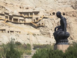 新疆ウイグル自治区アクス地区にあるキジル石窟群と鳩摩羅什の像。3世紀頃の西域仏教の寺院遺跡で、当時の亀茲国には1万人の僧侶が暮らしていた