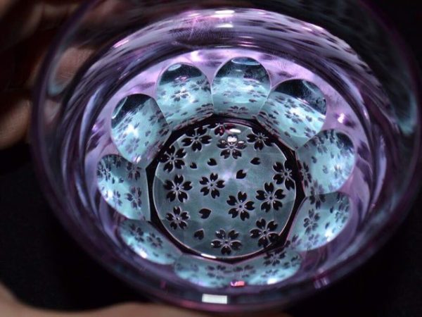 ▲椎名硝子伝統の平切子に三代目のサンドブラストの技術を組み合わせて誕生した『砂切子サクラサク』。お酒を注ぐと硝子の色彩が変化しサクラが花開いたように見える。※東京都内限定発売／砂切子サクラサク
