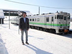 駅のホームに立つ亀海聡さん