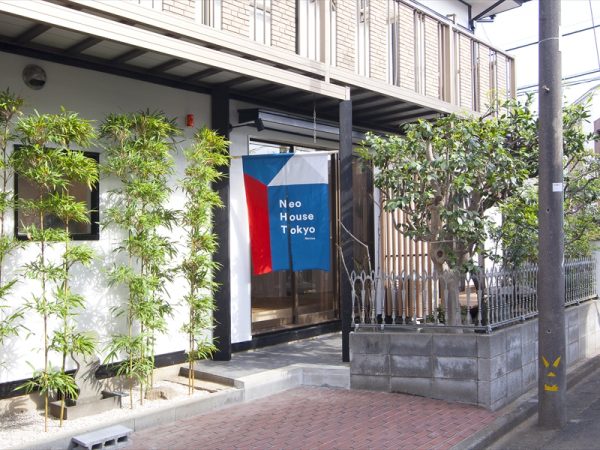 空き家だった白い外観の住宅をリノベーションして、リビング側にイベント参加者用の入り口をつくり、もともとの玄関は2階のシェアハウスの住人専用とした