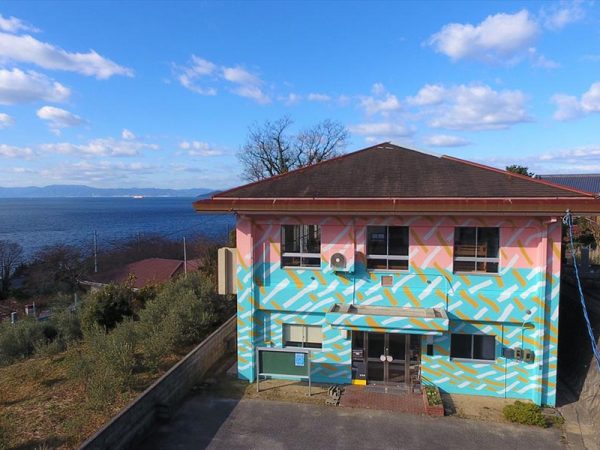 瀬戸内海に面したフウドは、崖地にあり景観が素晴らしい。特徴的な外壁は、インパクトを持たせたいと考えた後藤さんが、島の若いアーティストにお願いしたそうだ。近所のおじいさん、おばあさんたちからは、「派手なお菓子のようだね」と言われた