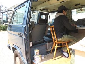 モバイルハウスで仕事中の西村氏。仲介業の場合、現地を案内するなど人と会わざるを得ない部分を除けばWi-Fiがあればできる作業もかなりある。改修の場合は現地に行かなくてはいけない。その２つをモバイルハウスを使うことでバランス良くこなしているといえそう