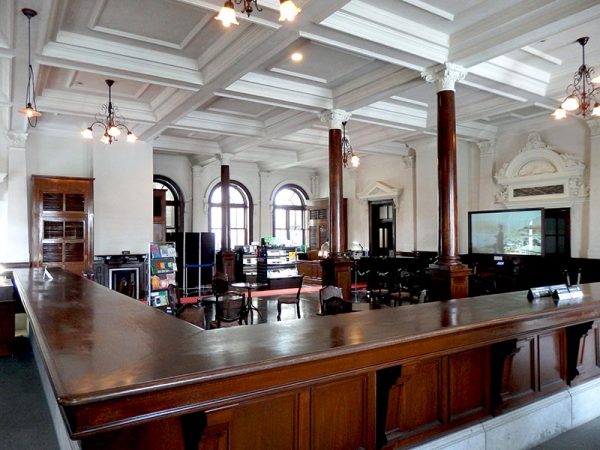 重厚感のある木のカウンターは、銀行窓口だったころを思わせる。現在この1階ホールは市民の多目的ホールとして利用できる