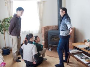 薪ストーブを調理器具として使う楽しみを提案する藤原社長（右）