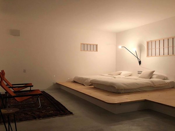 白を基調とした清潔でシンプルな部屋。小さな窓を開けると駅のホームが見える